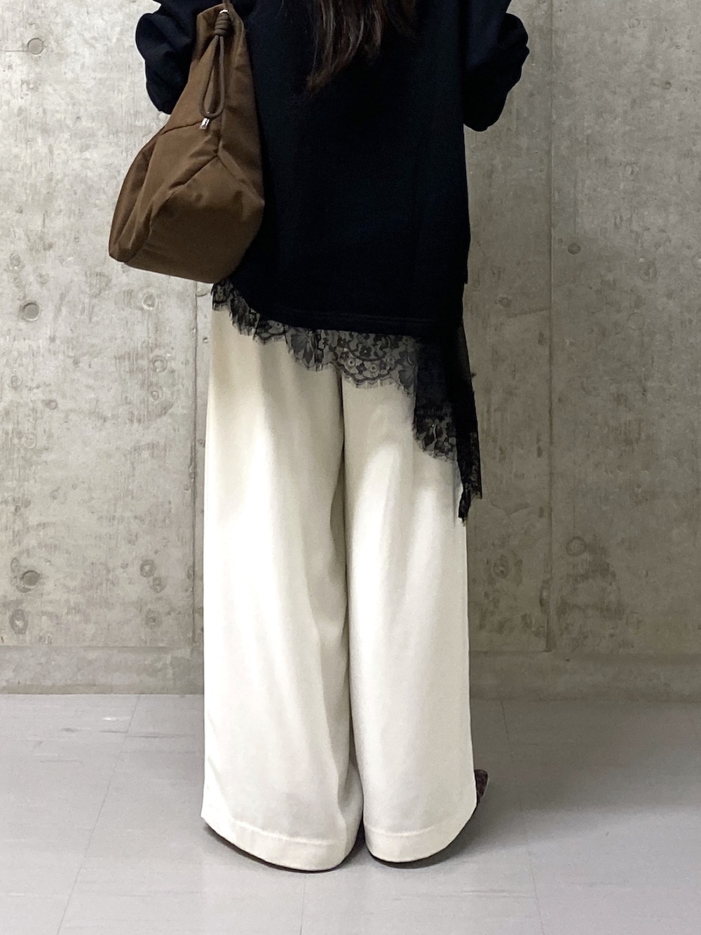 ホワイト系のスラックス、ブラック系のキャミソール、ブラック系のスウェットを着用したレディースの春コーディネートの6枚目の写真