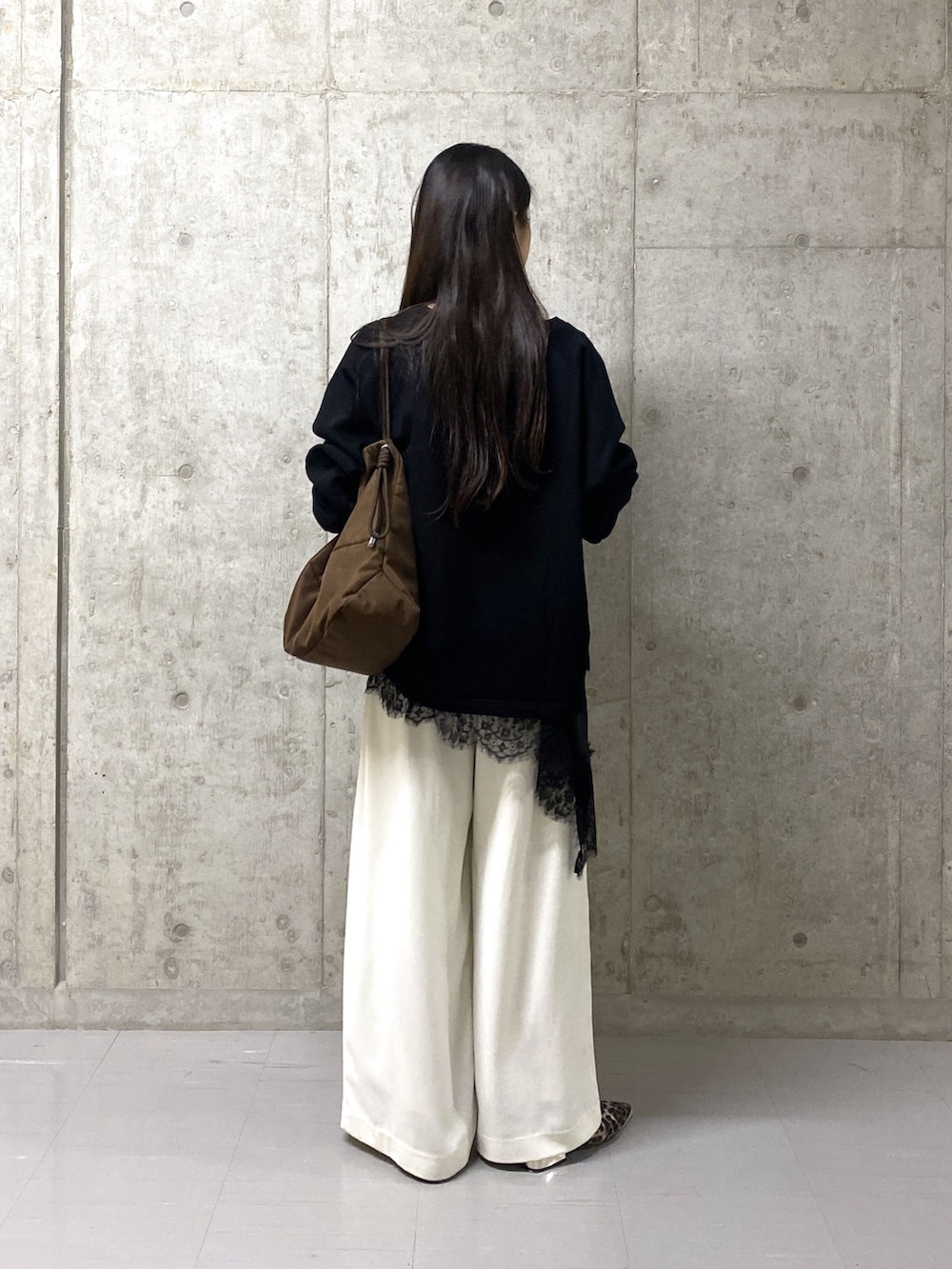 ホワイト系のスラックス、ブラック系のキャミソール、ブラック系のスウェットを着用したレディースの春コーディネートの2枚目の写真