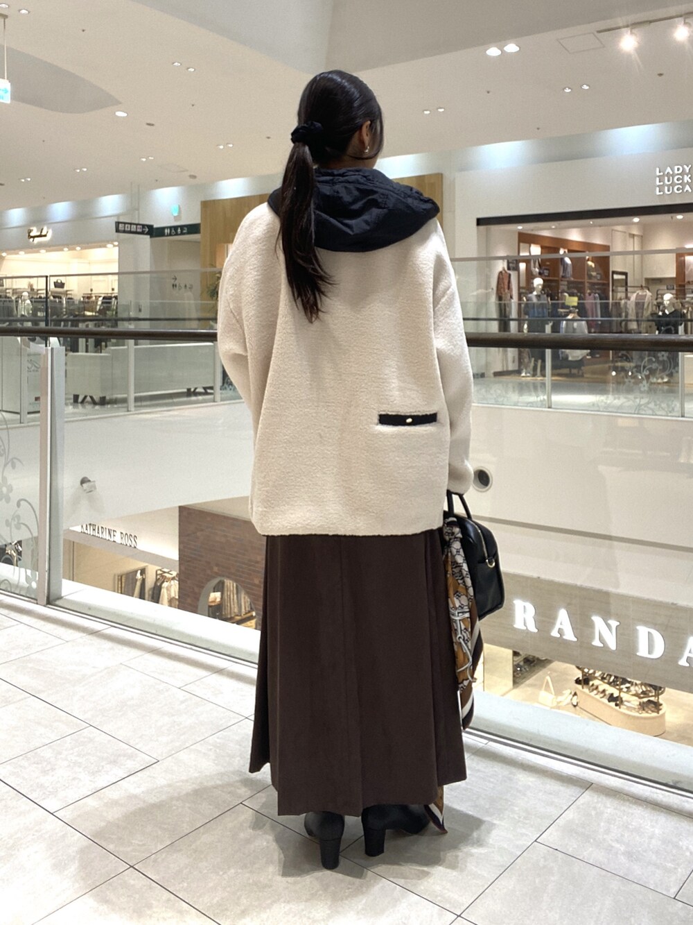 ホワイト系のその他アウター、ブラウン系のスカート、ブラック系のボストンバッグを着用したレディースの秋コーディネートの3枚目の写真