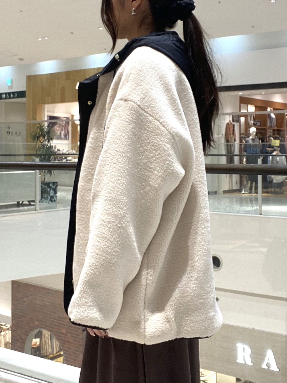 ホワイト系のその他アウター、ブラウン系のスカート、ブラック系のボストンバッグを着用したレディースの秋コーディネートの5枚目の写真