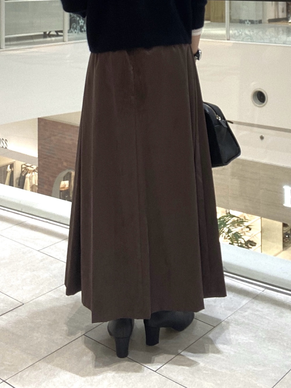 ホワイト系のその他アウター、ブラウン系のスカート、ブラック系のボストンバッグを着用したレディースの秋コーディネートの9枚目の写真