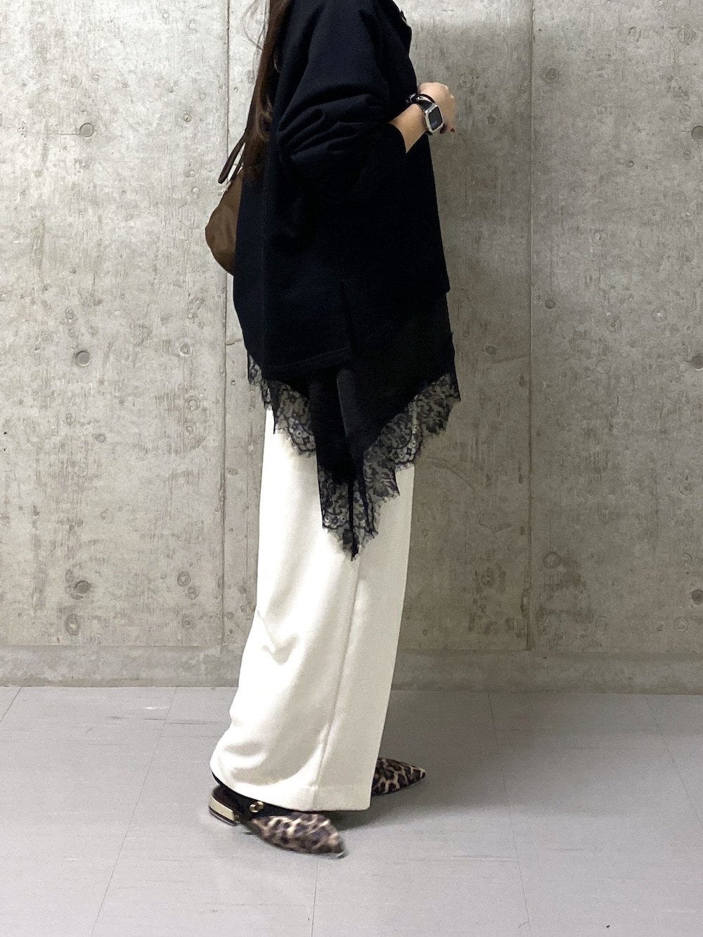 ホワイト系のスラックス、ブラック系のキャミソール、ブラック系のスウェットを着用したレディースの春コーディネートの5枚目の写真