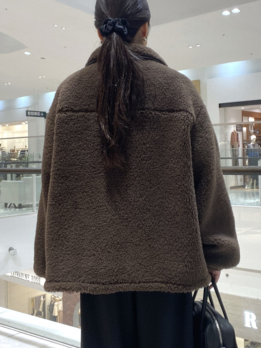 ブラウン系のその他アウター、ブラック系のスラックス、ブラック系のブーツを着用したレディースの秋コーディネートの6枚目の写真