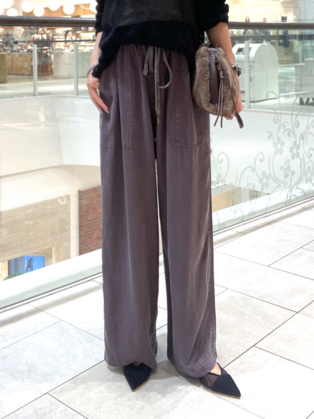 ブラック系のスウェット、グレー系のその他パンツ、ブラウン系のハンドバッグを着用したレディースの夏コーディネートの7枚目の写真