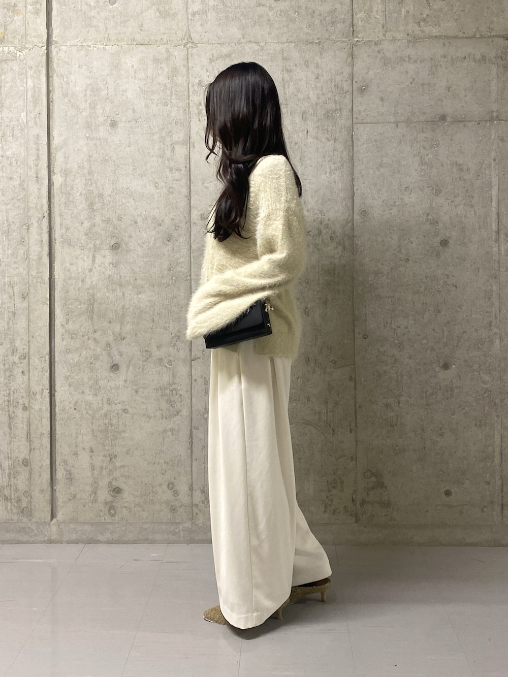 ホワイト系のニット/セーター、ホワイト系のスラックス、ベージュ系のその他シューズを着用したレディースの冬コーディネートの2枚目の写真