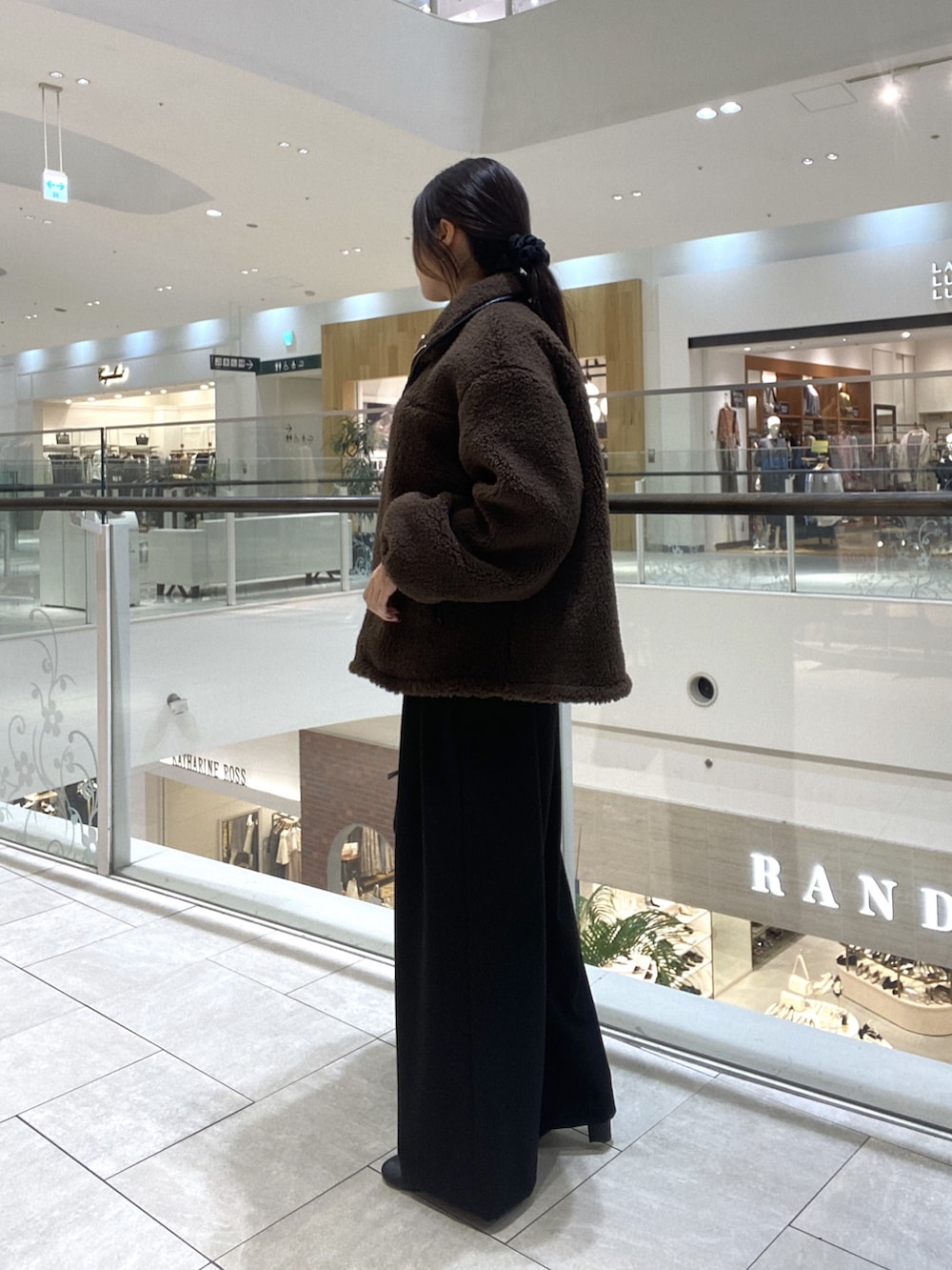 ブラウン系のその他アウター、ブラック系のスラックス、ブラック系のブーツを着用したレディースの秋コーディネートの2枚目の写真