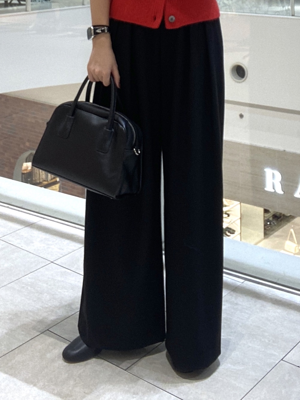 レッド系のカーディガン/ボレロ、ブラック系のスラックス、ブラック系のボストンバッグを着用したレディースの秋コーディネートの7枚目の写真