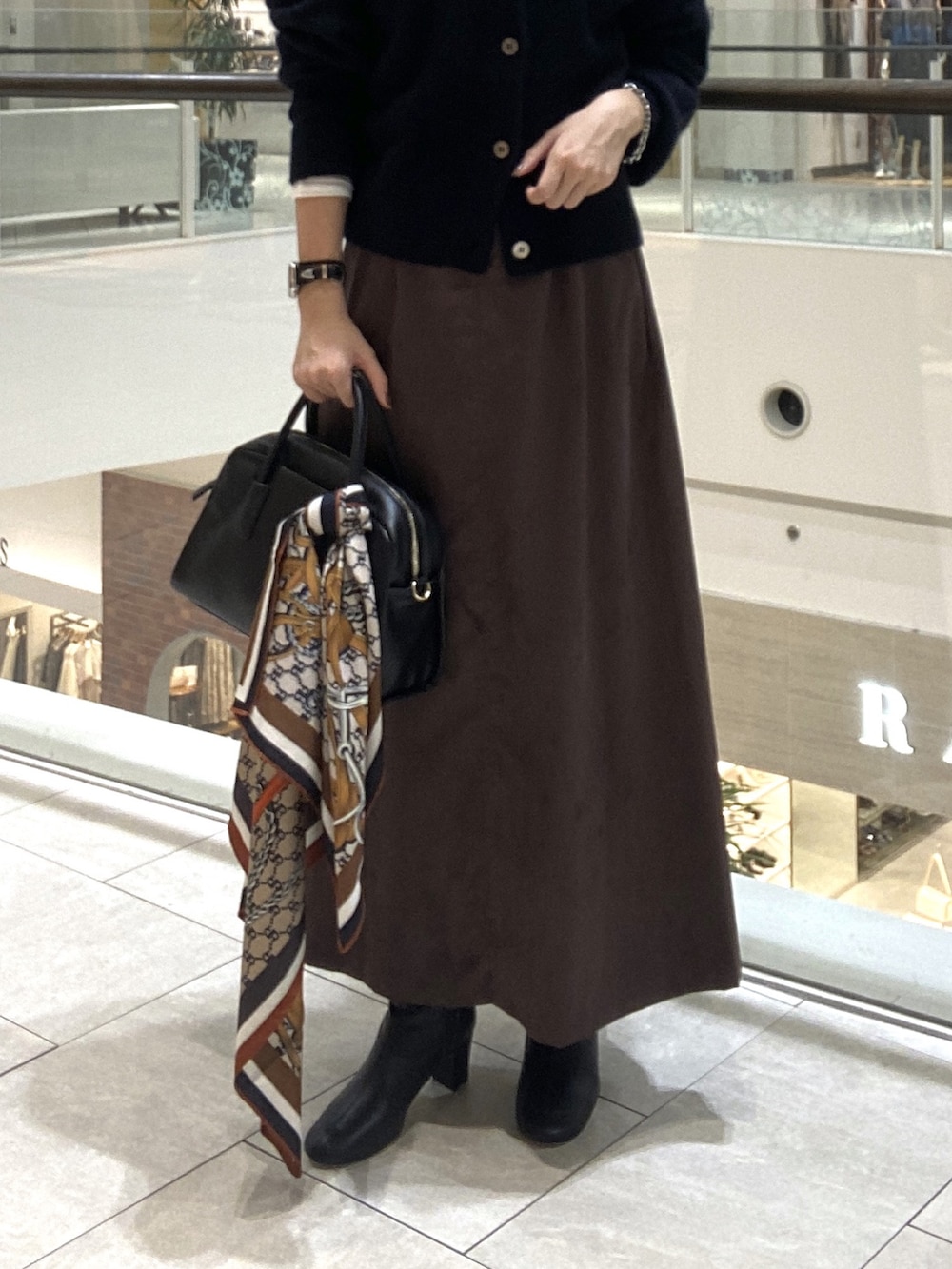 ホワイト系のその他アウター、ブラウン系のスカート、ブラック系のボストンバッグを着用したレディースの秋コーディネートの7枚目の写真