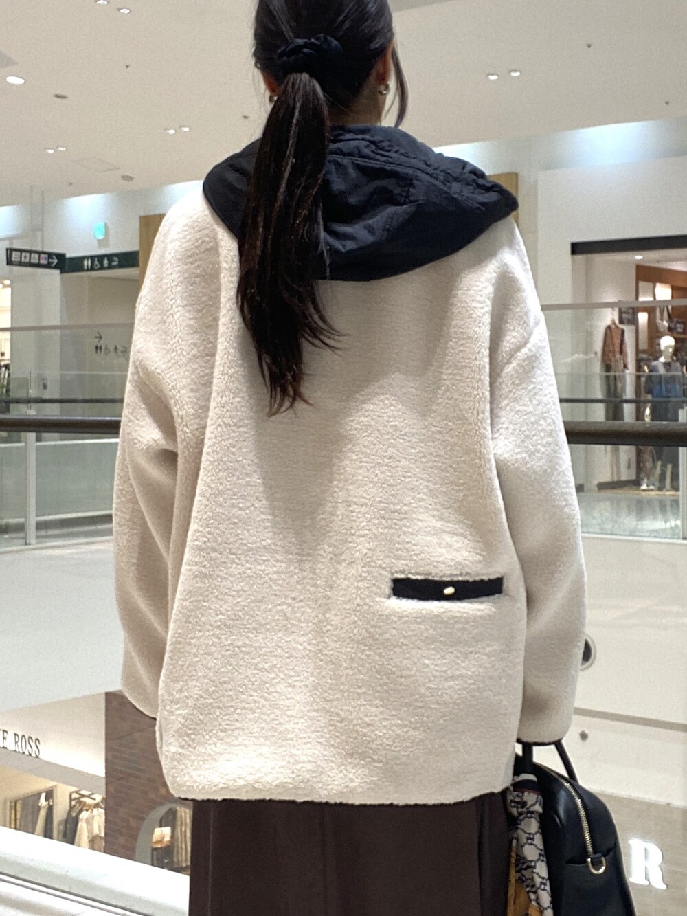 ホワイト系のその他アウター、ブラウン系のスカート、ブラック系のボストンバッグを着用したレディースの秋コーディネートの6枚目の写真