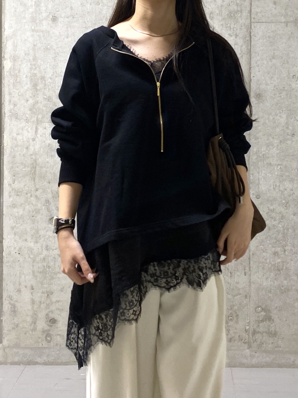 ホワイト系のスラックス、ブラック系のキャミソール、ブラック系のスウェットを着用したレディースの春コーディネートの3枚目の写真