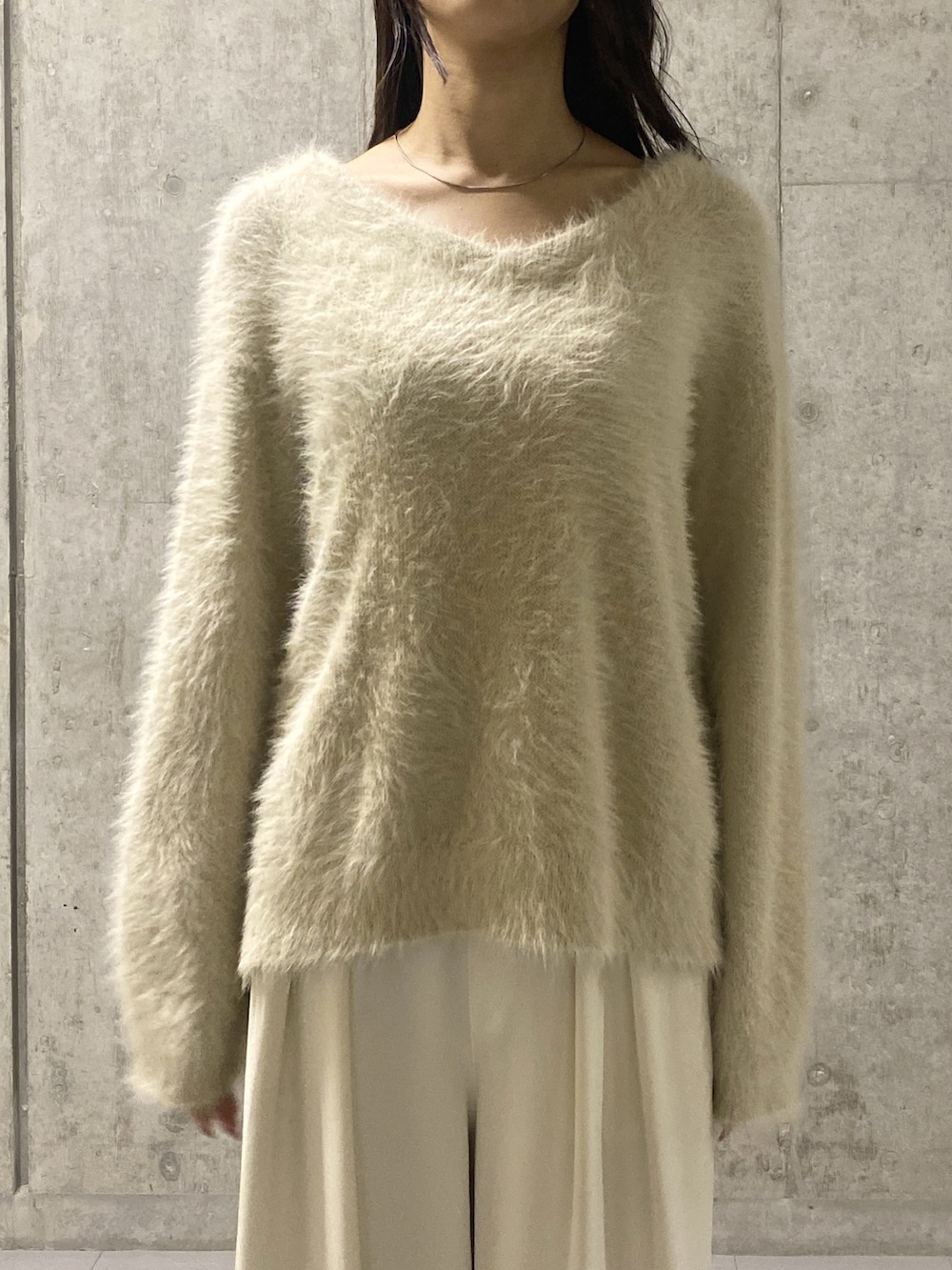 ホワイト系のニット/セーター、ホワイト系のスラックス、ベージュ系のその他シューズを着用したレディースの冬コーディネートの4枚目の写真