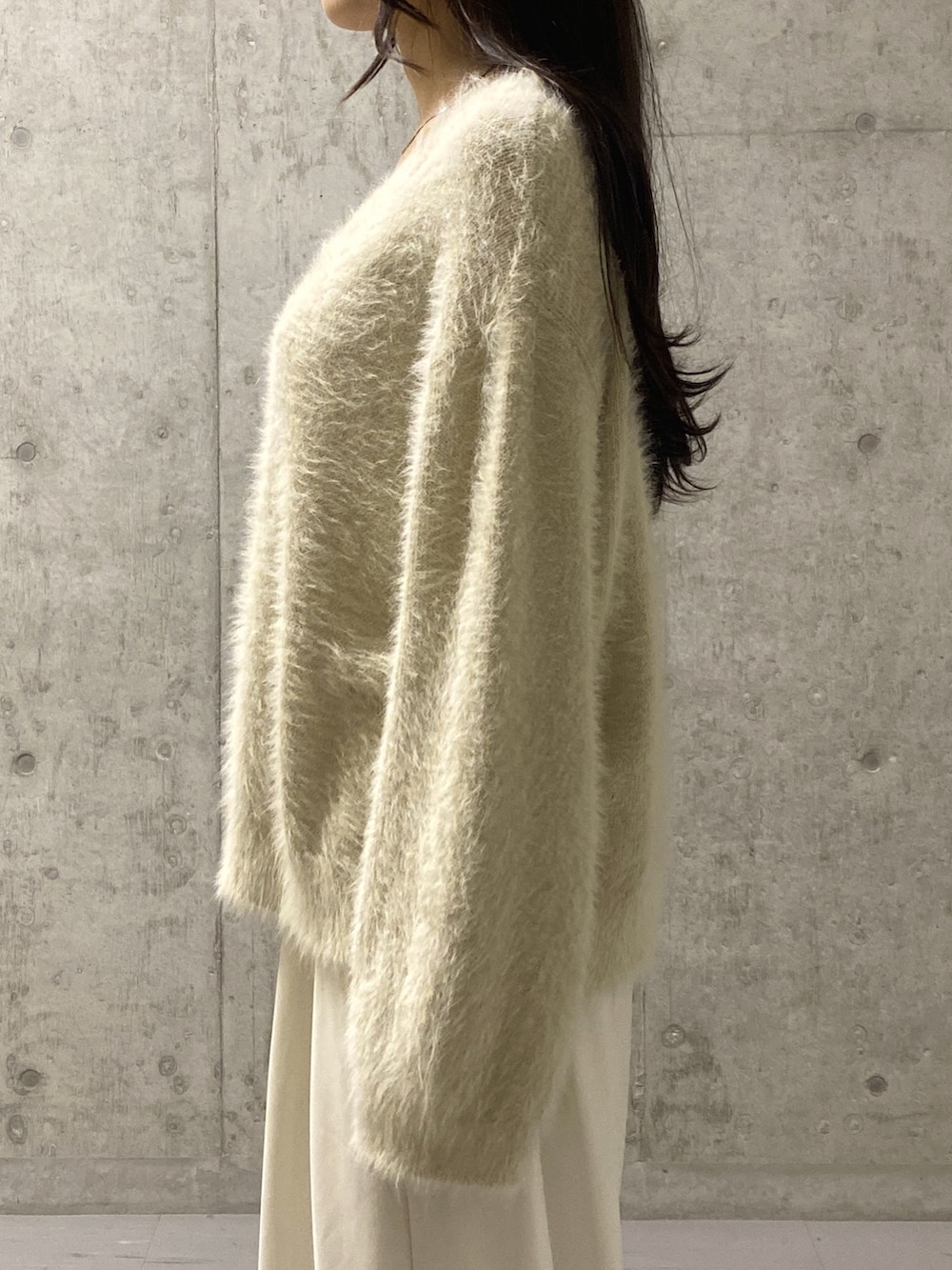 ホワイト系のニット/セーター、ホワイト系のスラックス、ベージュ系のその他シューズを着用したレディースの冬コーディネートの5枚目の写真