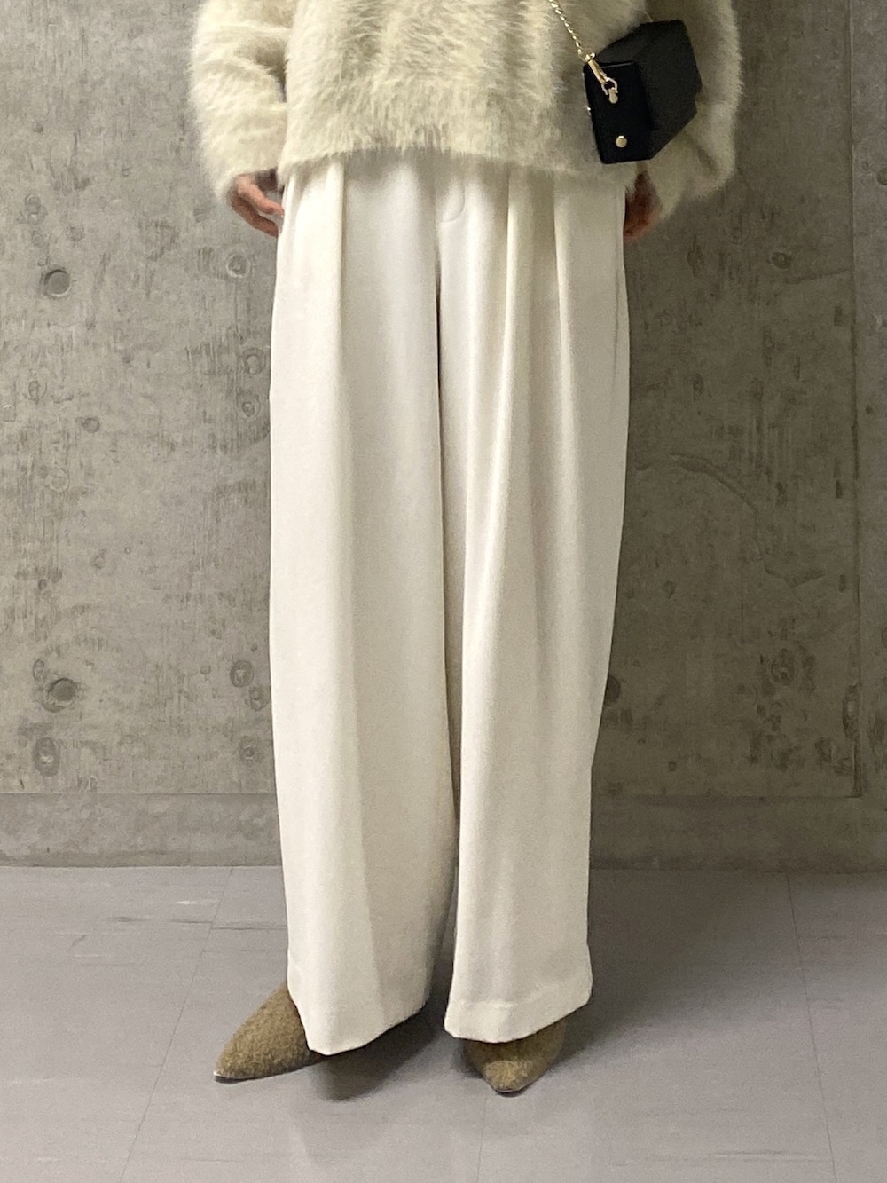 ホワイト系のニット/セーター、ホワイト系のスラックス、ベージュ系のその他シューズを着用したレディースの冬コーディネートの7枚目の写真