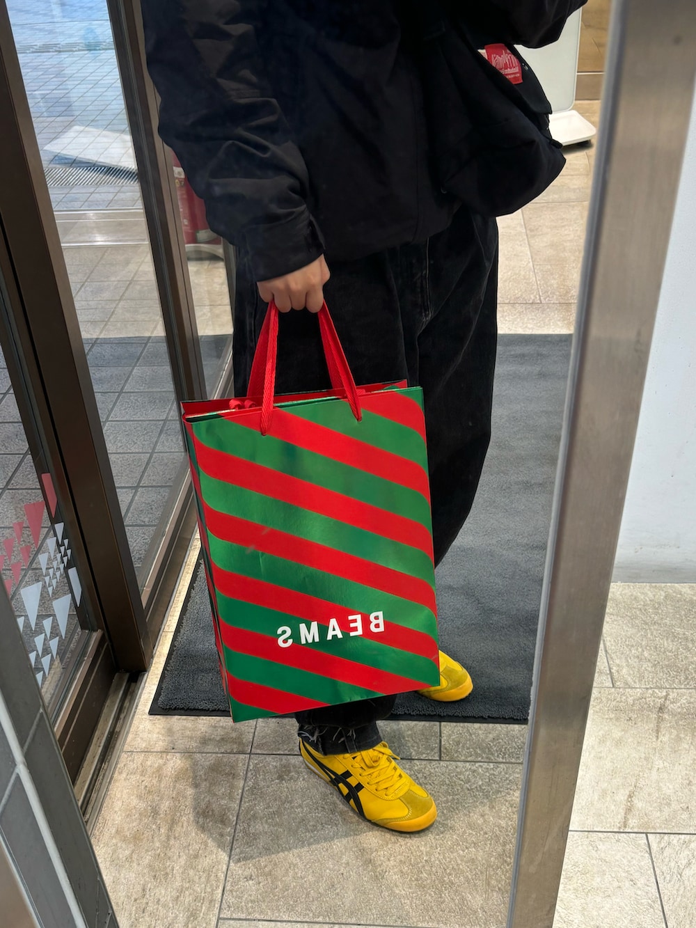 ブラック系のデニムパンツ、ブラック系のショルダーバッグ、ブラック系のマウンテンパーカーを着用したレディースの冬コーディネートの2枚目の写真