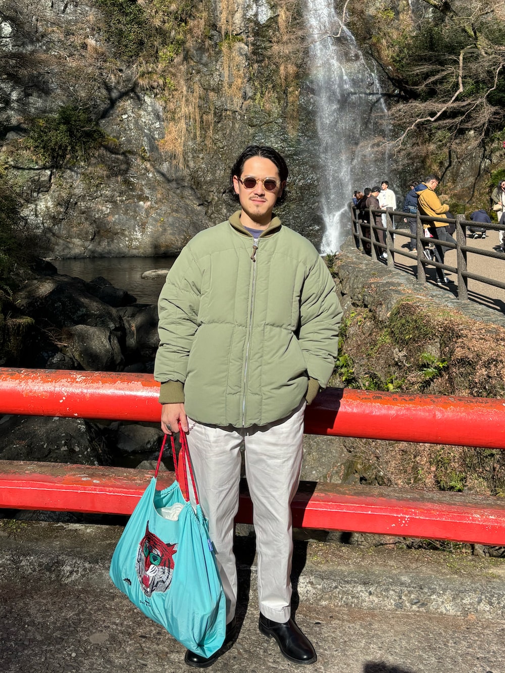 グリーン系のダウンジャケット/コート、ブラック系のスウェット、ホワイト系のチノパンツを着用したメンズの冬コーディネートの2枚目の写真