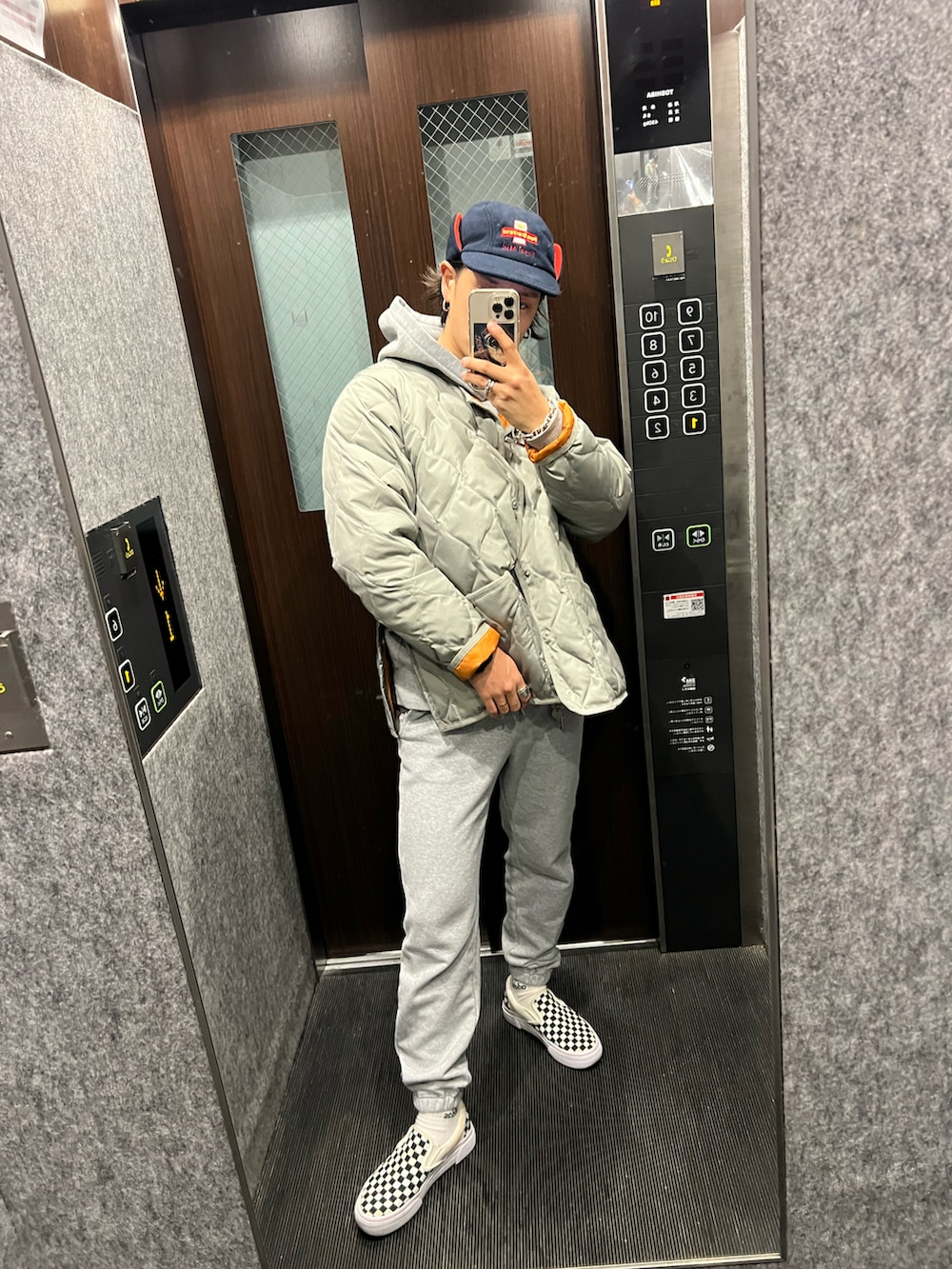 グレー系のスウェットパンツ、その他のスリッポン、グリーン系のダウンジャケット/コートを着用したメンズの冬コーディネートの2枚目の写真