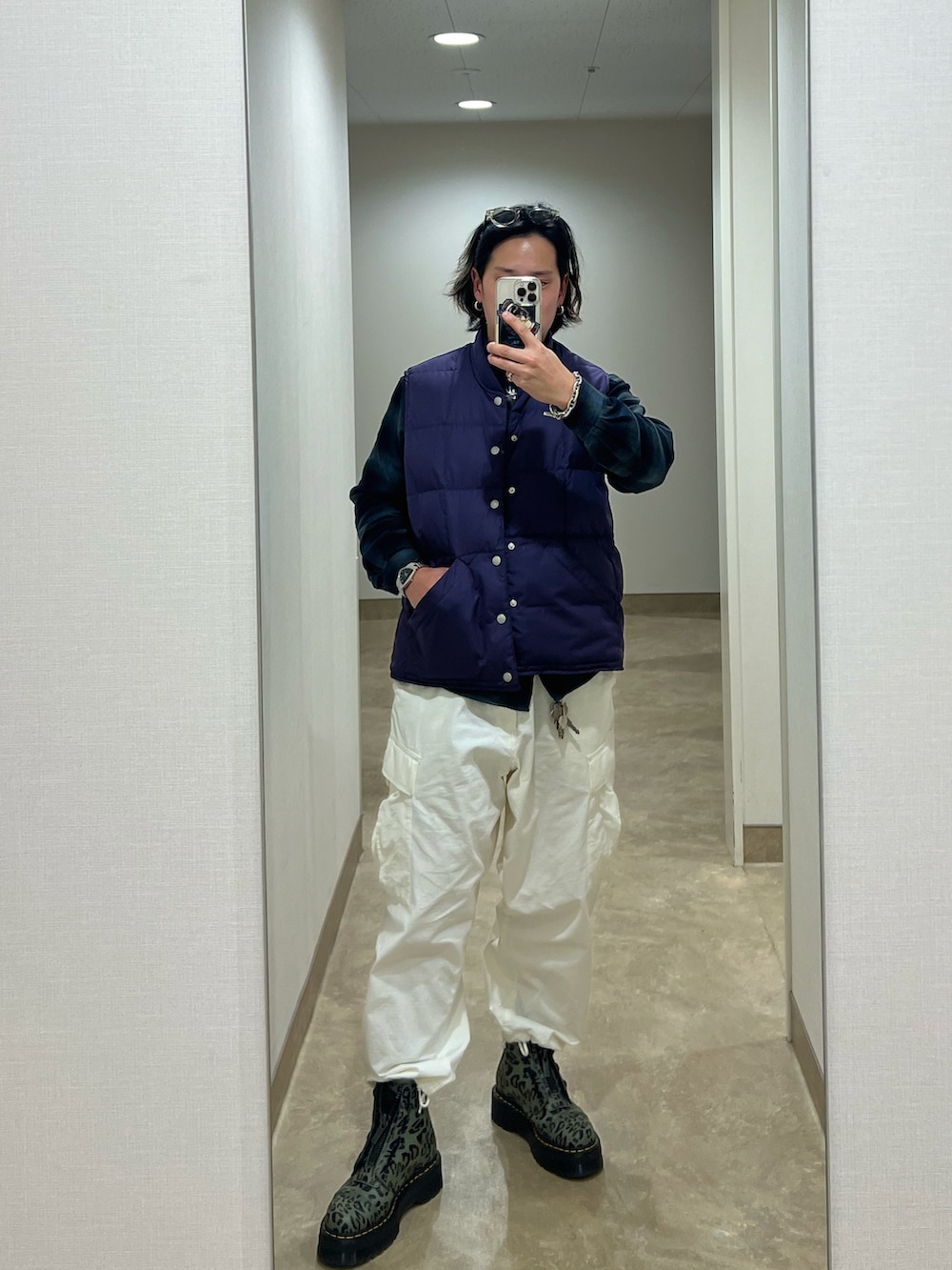 ホワイト系のカーゴパンツ、その他のブーツ、パープル系のダウンベストを着用したメンズの冬コーディネートの2枚目の写真