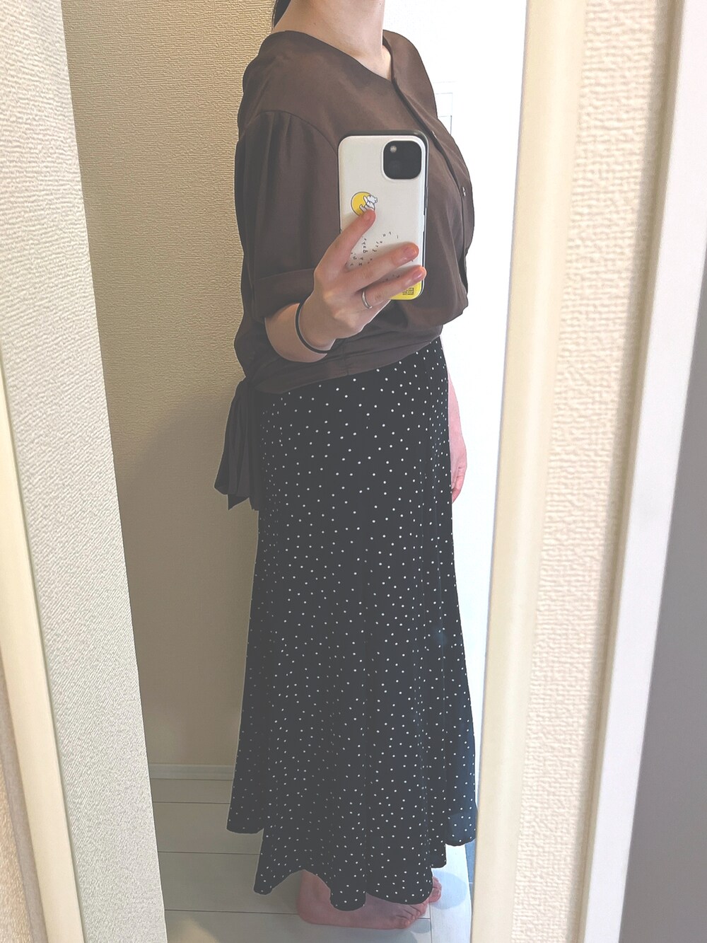 ブラウン系のトップス、ブラック系のスカートを着用したレディースの夏コーディネートの2枚目の写真