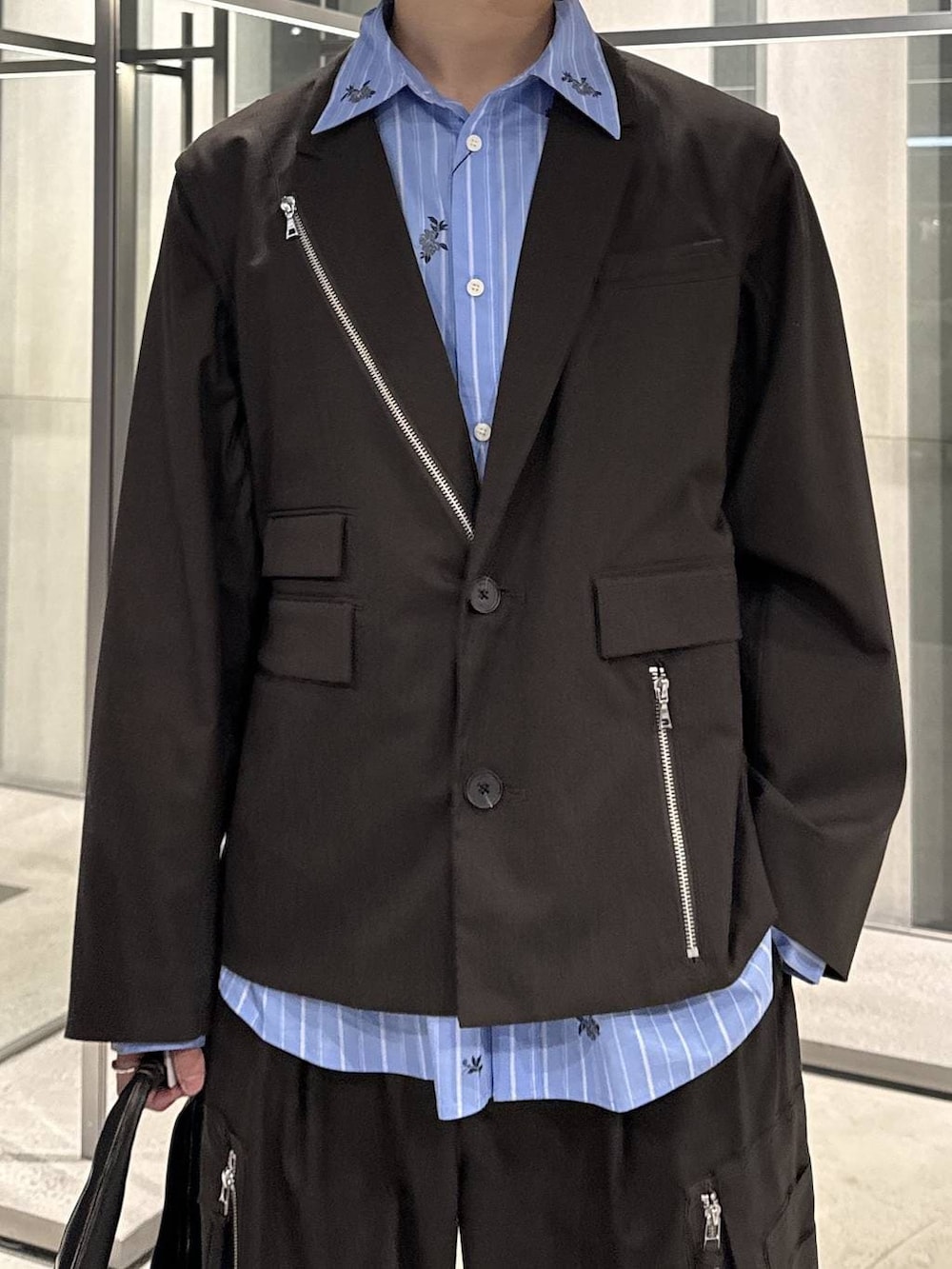 ブラック系のトートバッグ、ブラウン系のテーラードジャケット、ブラウン系のカーゴパンツを着用したメンズの春コーディネートの3枚目の写真