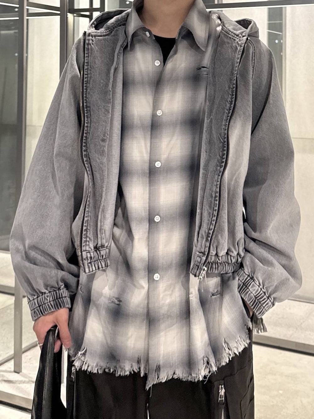 ブラック系のトートバッグ、ブラック系のTシャツ/カットソー、グレー系のブルゾンを着用したメンズの春コーディネートの3枚目の写真