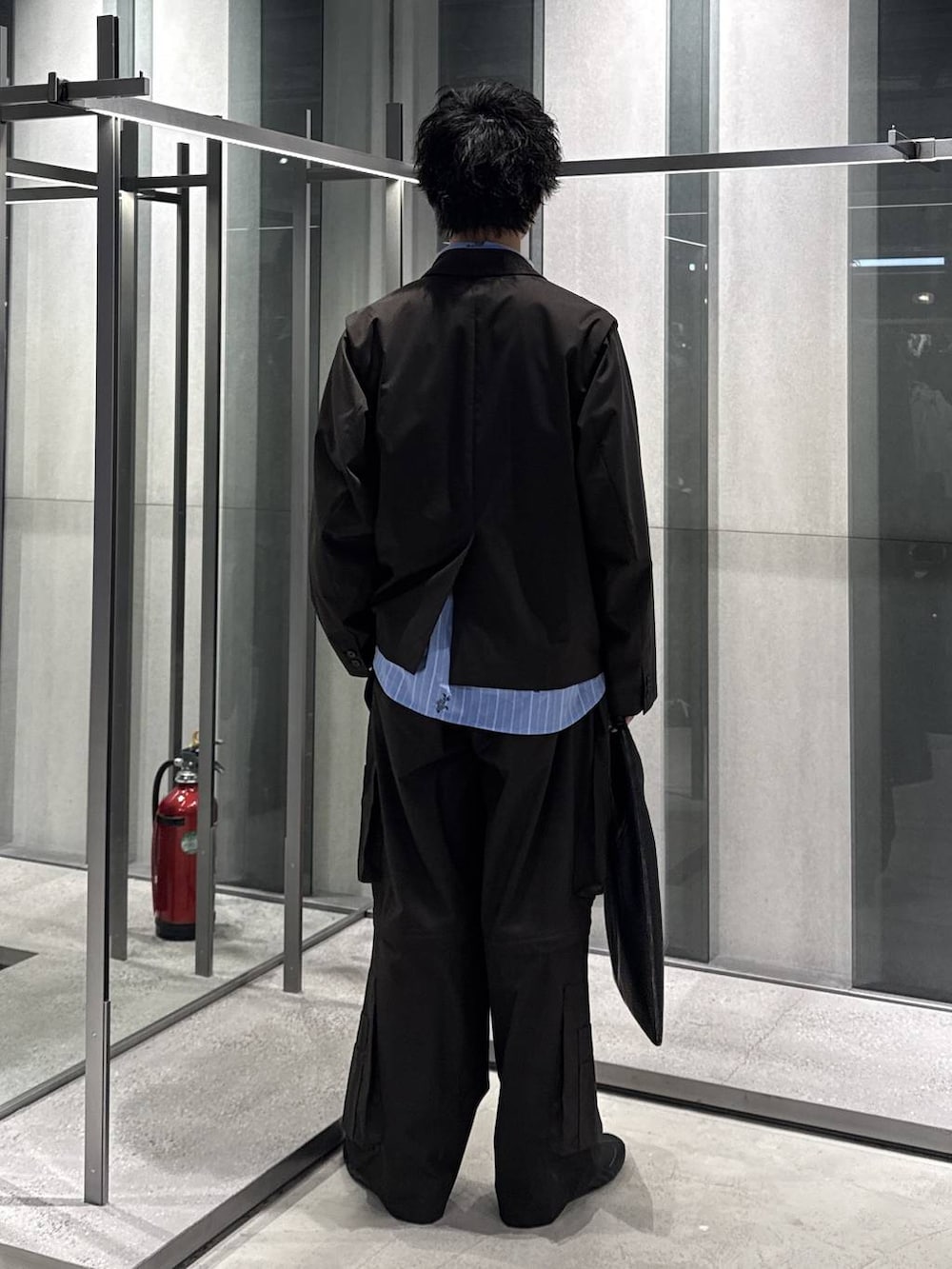 ブラック系のトートバッグ、ブラウン系のテーラードジャケット、ブラウン系のカーゴパンツを着用したメンズの春コーディネートの2枚目の写真