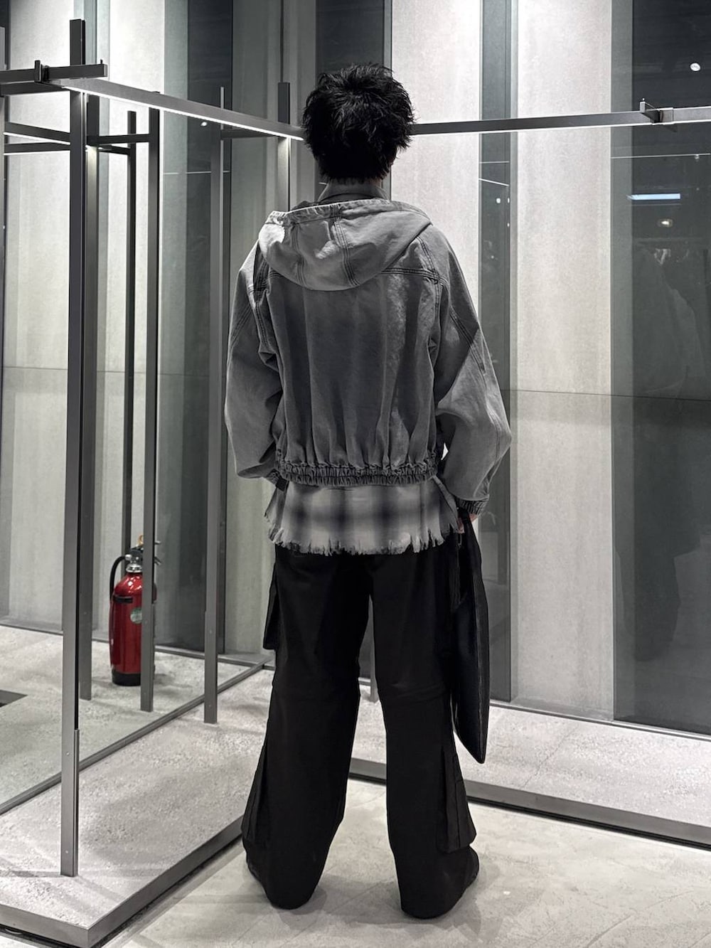 ブラック系のトートバッグ、ブラック系のTシャツ/カットソー、グレー系のブルゾンを着用したメンズの春コーディネートの2枚目の写真