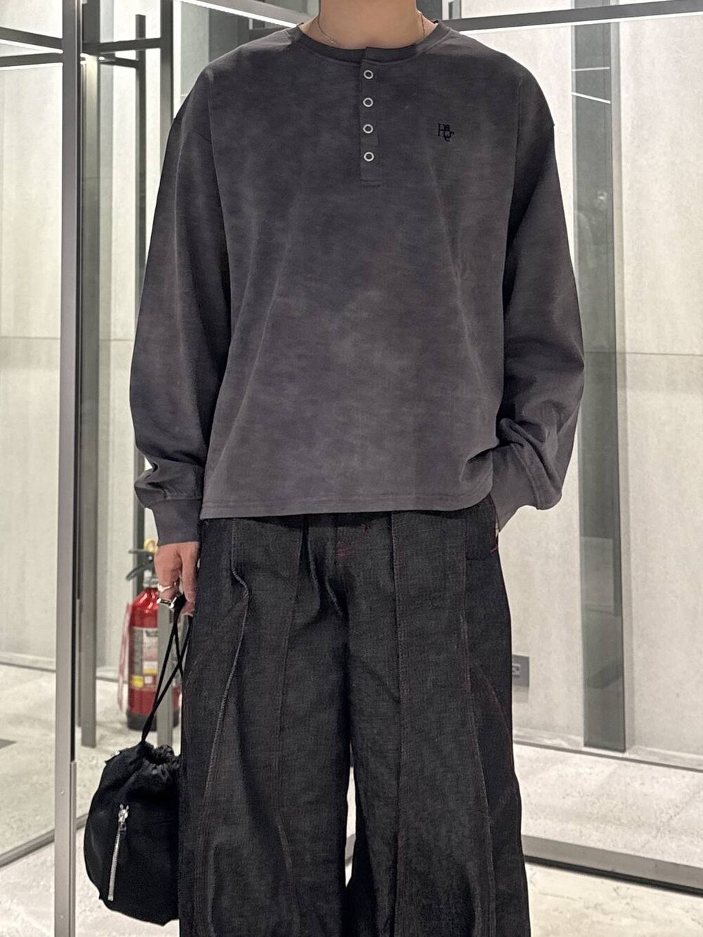ブラック系のショルダーバッグ、グレー系のTシャツ/カットソー、ブラック系のスニーカーを着用したメンズの秋コーディネートの3枚目の写真