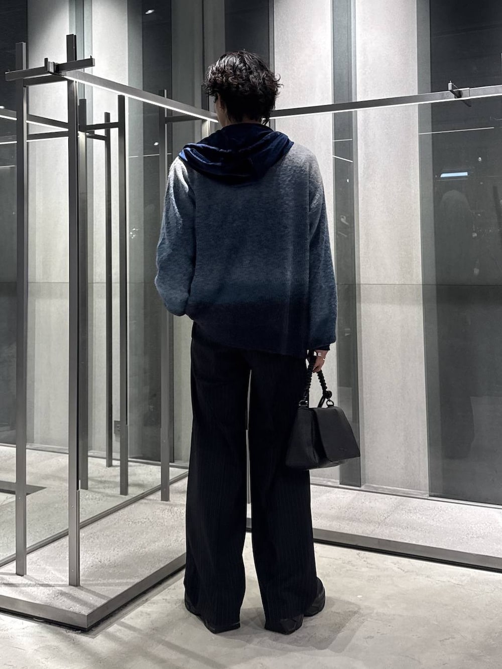 ブルー系のカーディガン/ボレロ、ブラック系のスラックス、ブラック系のショルダーバッグを着用したメンズの秋コーディネートの2枚目の写真