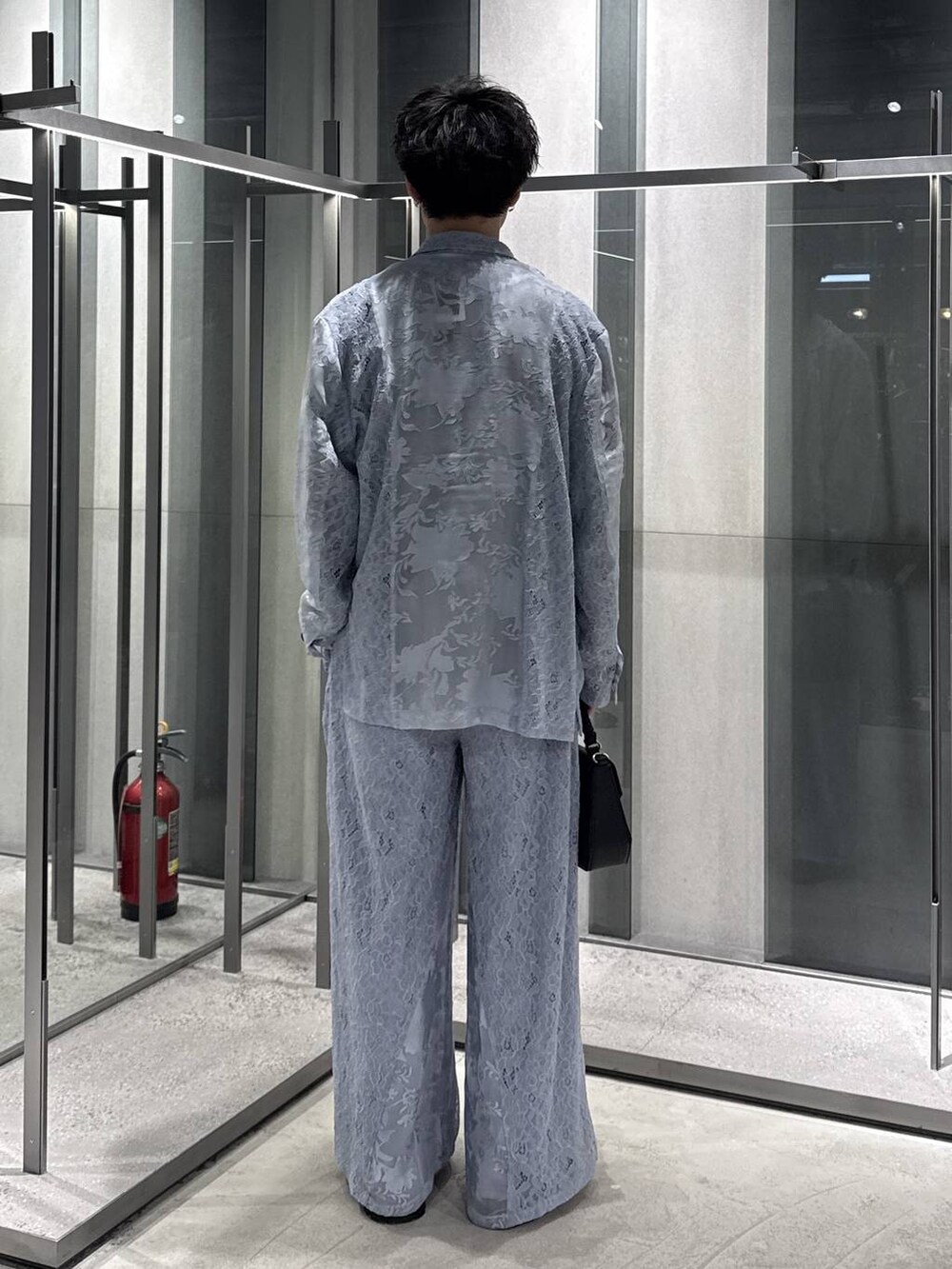 ブラック系のドレスシューズ、ブラック系のショルダーバッグ、ブルー系のTシャツ/カットソーを着用したメンズの春コーディネートの2枚目の写真