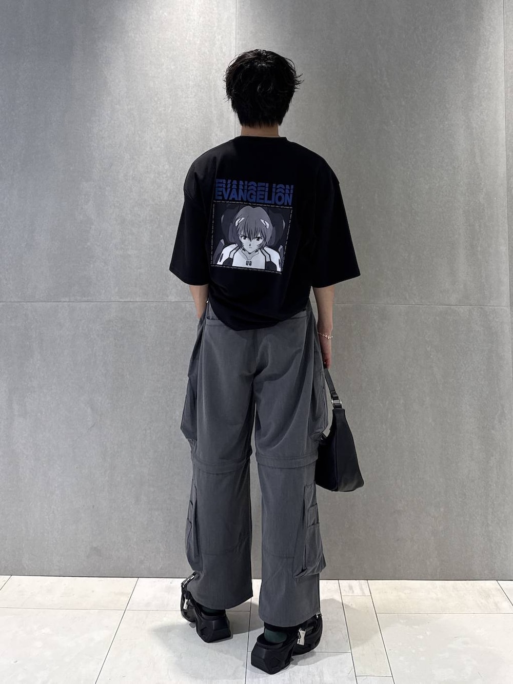 ブラック系のTシャツ/カットソー、ブラック系のサンダル、グレー系のカーゴパンツを着用したメンズの夏コーディネートの2枚目の写真