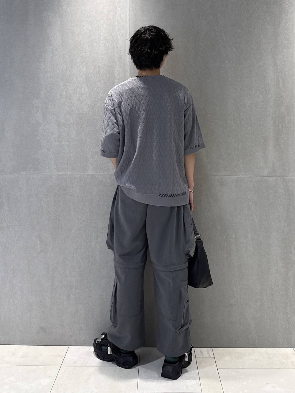 ブラック系のサンダル、ブラック系のTシャツ/カットソー、グレー系のカーゴパンツを着用したメンズの夏コーディネートの2枚目の写真