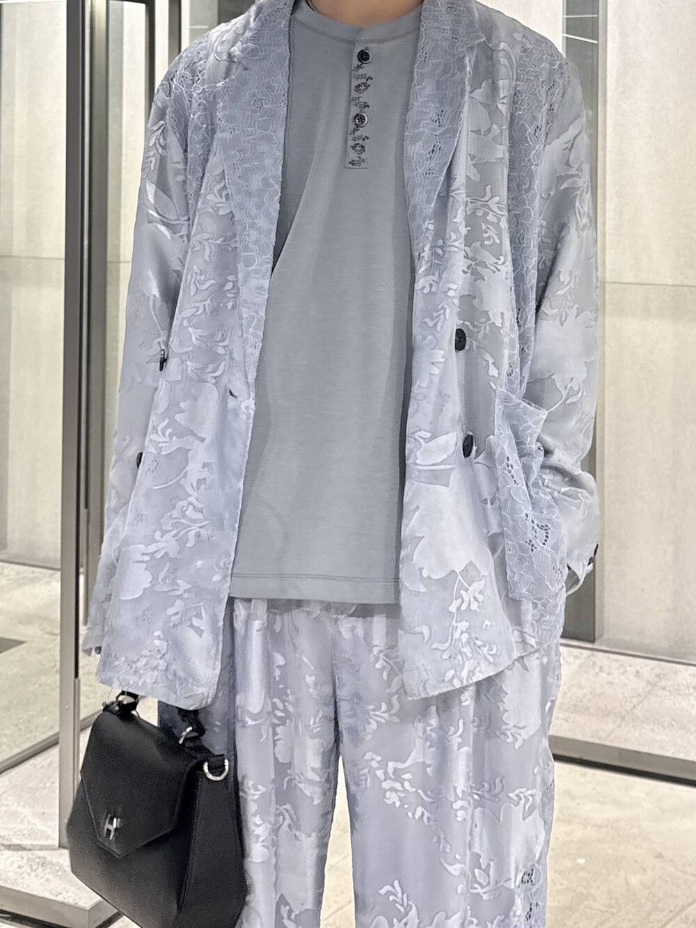 ブラック系のドレスシューズ、ブラック系のショルダーバッグ、ブルー系のTシャツ/カットソーを着用したメンズの春コーディネートの3枚目の写真