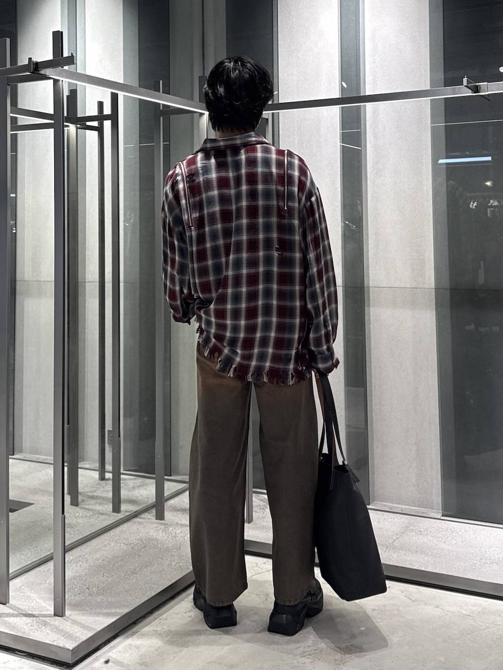 ブラウン系のデニムパンツ、ブラック系のローファー、ブラック系のTシャツ/カットソーを着用したメンズの夏コーディネートの2枚目の写真