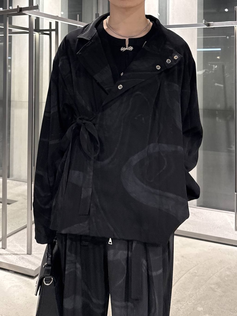 グレー系のその他パンツ、ブラック系のドレスシューズ、ブラック系のショルダーバッグを着用したメンズの春コーディネートの3枚目の写真