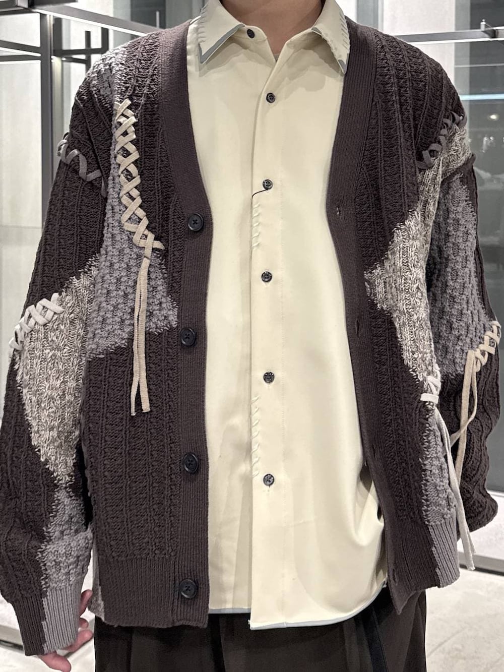 ブラウン系のカーディガン/ボレロ、ベージュ系のシャツ/ブラウス、ブラック系のローファーを着用したメンズの春コーディネートの3枚目の写真