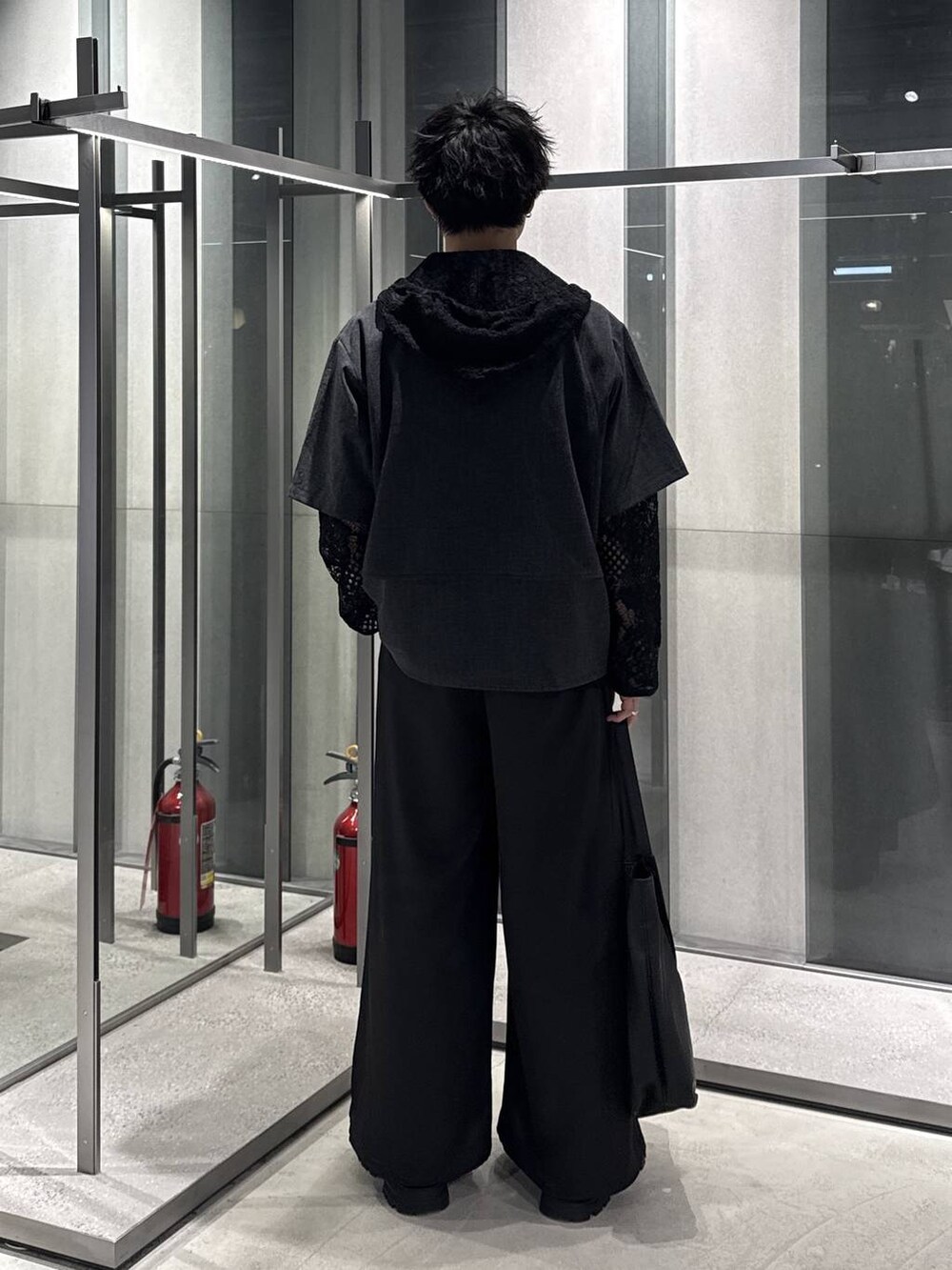 ブラック系のドレスシューズ、ブラック系のトートバッグ、ブラック系のスラックスを着用したメンズの春コーディネートの2枚目の写真