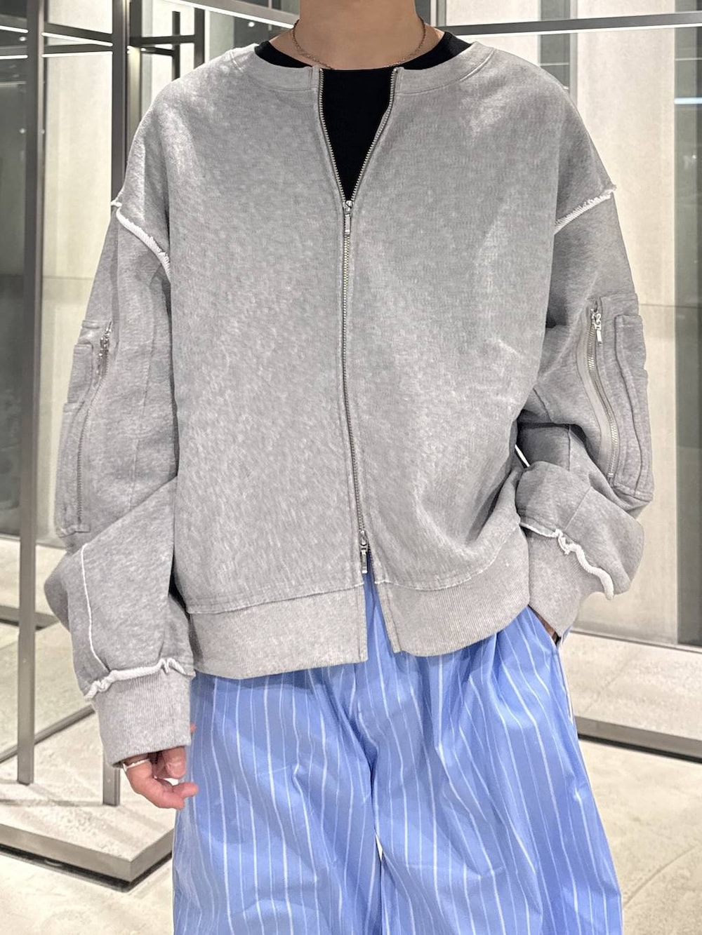 ブラック系のTシャツ/カットソー、ブルー系のスラックス、グレー系のスウェットを着用したメンズの春コーディネートの3枚目の写真