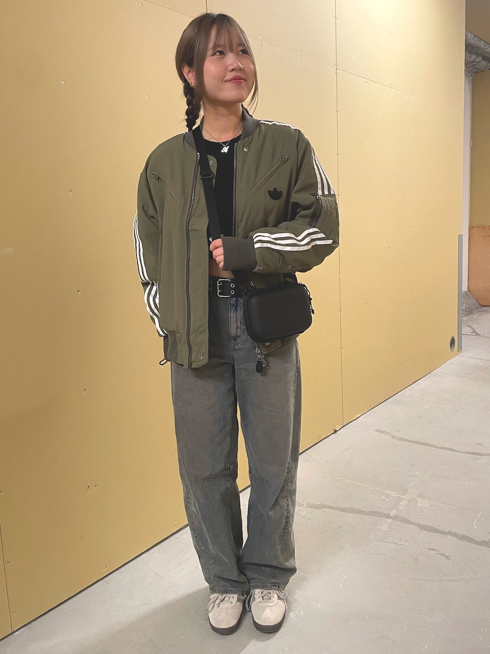 グリーン系のダウンジャケット/コート、ベージュ系のスニーカー、ブラック系のショルダーバッグを着用したレディースの秋コーディネートの2枚目の写真
