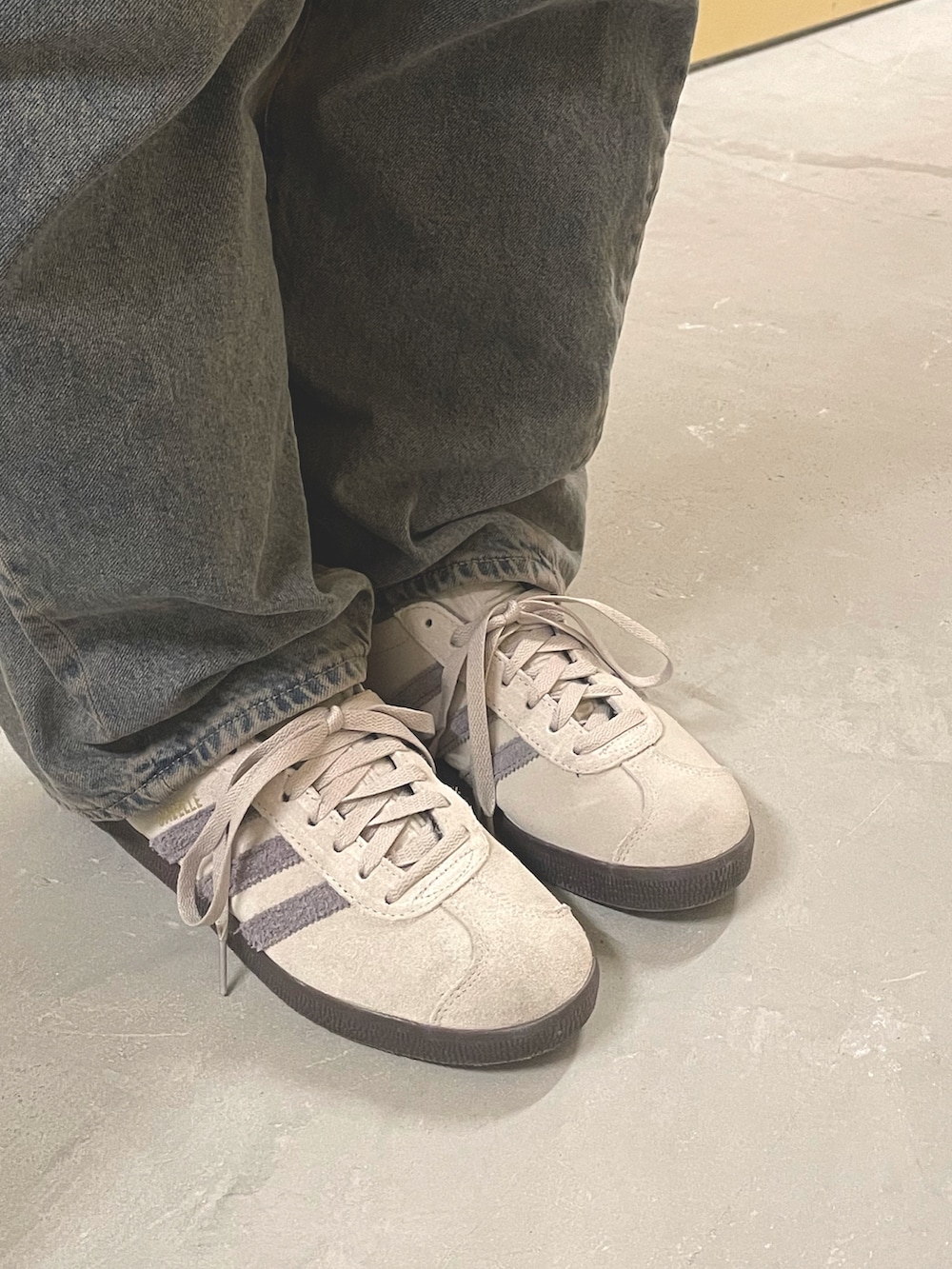 グリーン系のダウンジャケット/コート、ベージュ系のスニーカー、ブラック系のショルダーバッグを着用したレディースの秋コーディネートの4枚目の写真