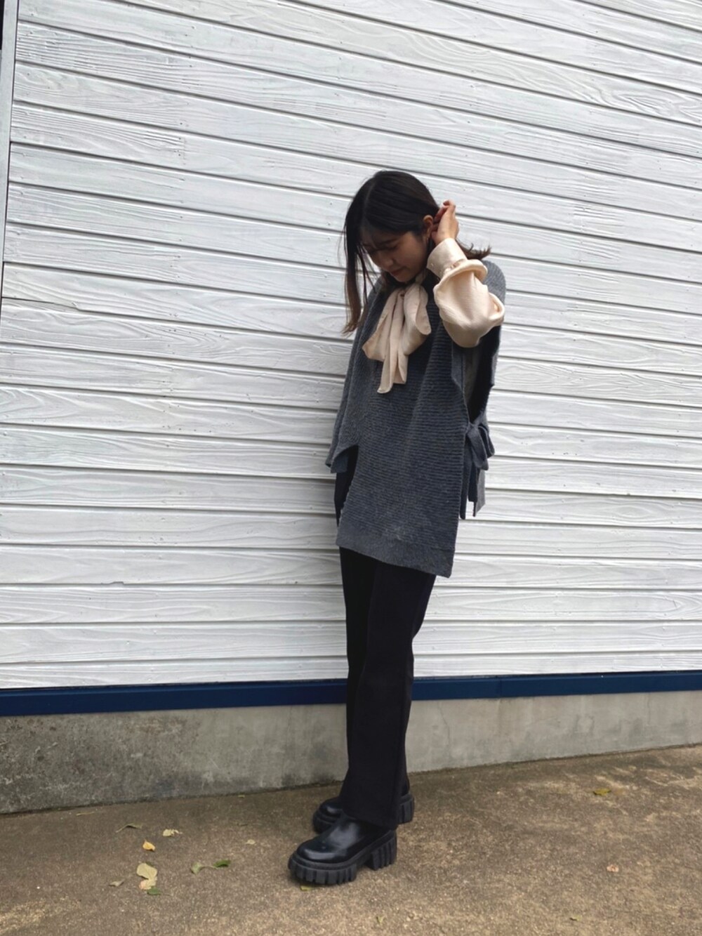 ホワイト系のシャツ/ブラウス、グレー系のニット/セーター、ブラック系のその他パンツを着用したレディースの秋コーディネートの3枚目の写真