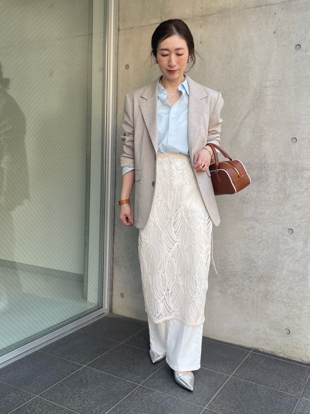 ブルー系のシャツ/ブラウス、ベージュ系のテーラードジャケット、ホワイト系のスカートを着用したレディースの冬コーディネートの6枚目の写真