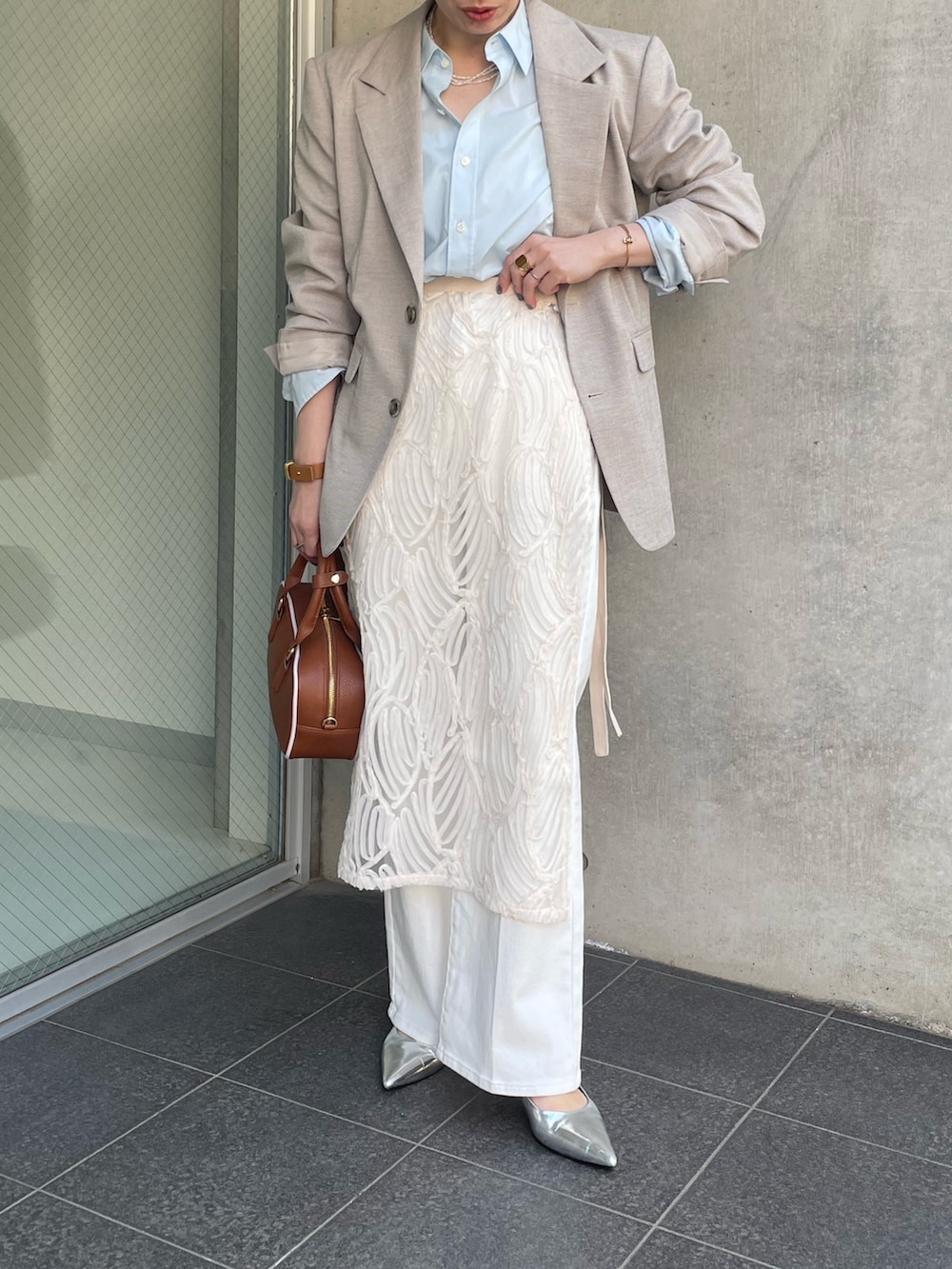 ブルー系のシャツ/ブラウス、ベージュ系のテーラードジャケット、ホワイト系のスカートを着用したレディースの冬コーディネートの2枚目の写真