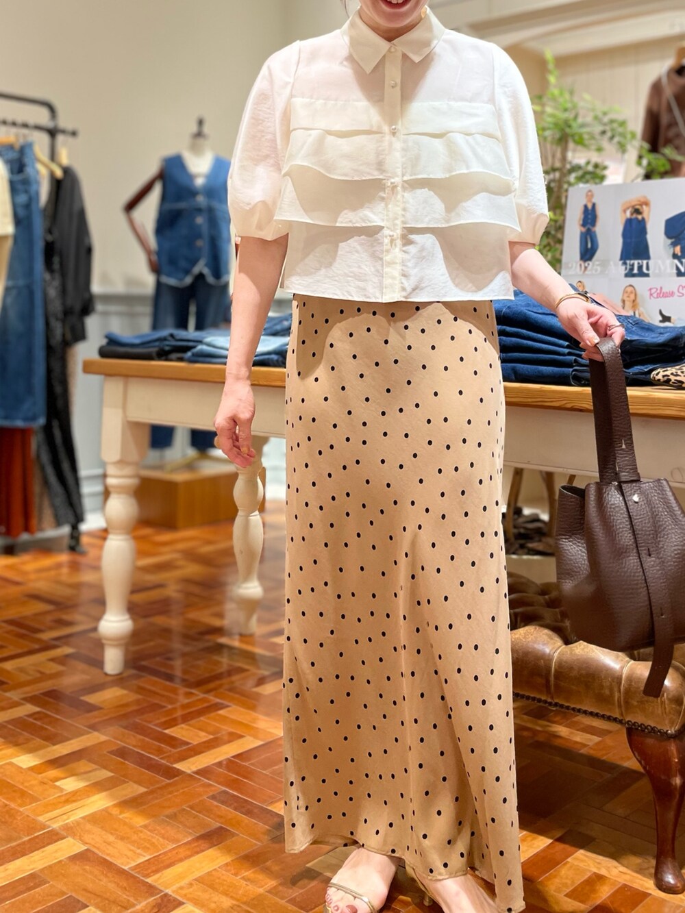 ホワイト系のシャツ/ブラウス、ブラウン系のスカート、ブラウン系のショルダーバッグを着用したレディースの秋コーディネートの3枚目の写真