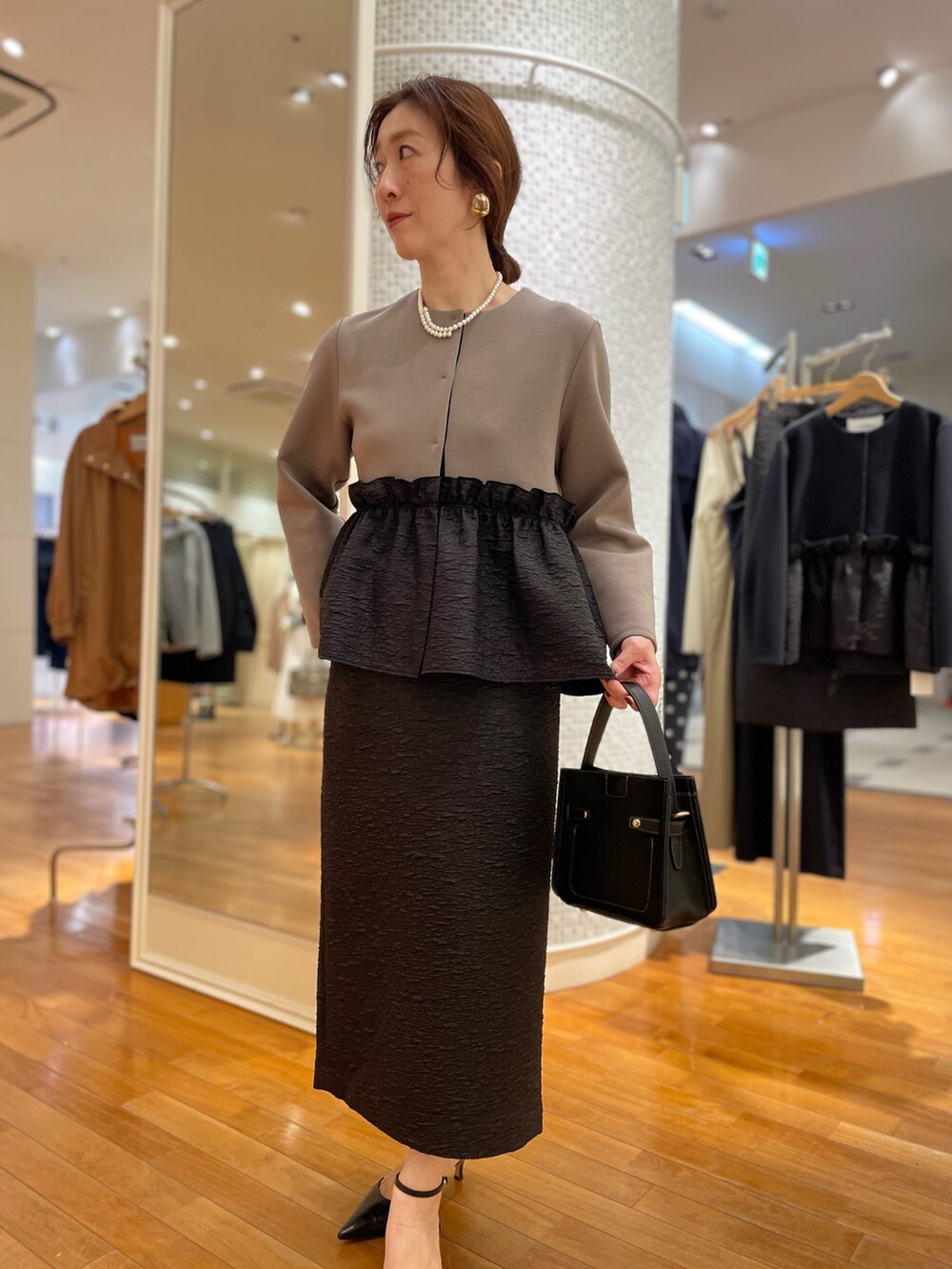 グリーン系のブルゾン、ブラック系のスカート、ブラック系のショルダーバッグを着用したレディースの秋コーディネートの8枚目の写真