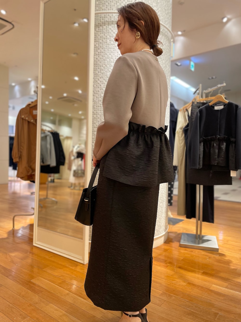 グリーン系のブルゾン、ブラック系のスカート、ブラック系のショルダーバッグを着用したレディースの秋コーディネートの7枚目の写真