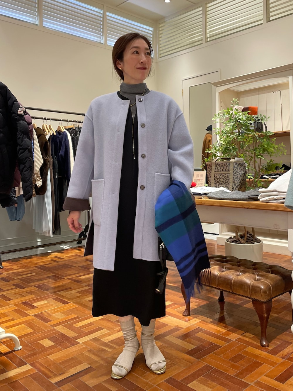 ブラウン系のノーカラーコート、ブラック系のワンピース、グレー系のニット/セーターを着用したレディースの冬コーディネートの9枚目の写真