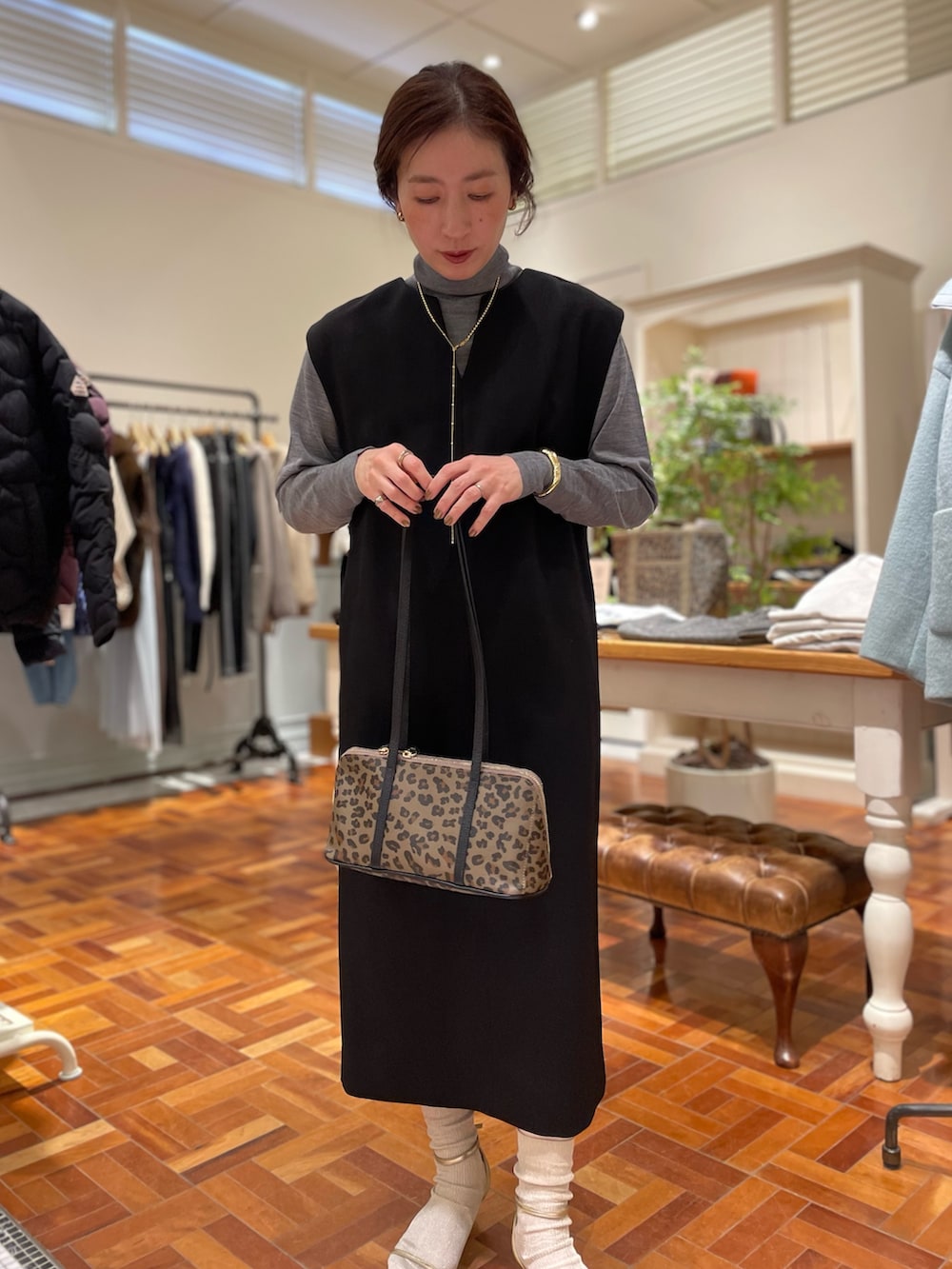 ブラック系のワンピース、グレー系のニット/セーター、ベージュ系のショルダーバッグを着用したレディースの冬コーディネートの5枚目の写真