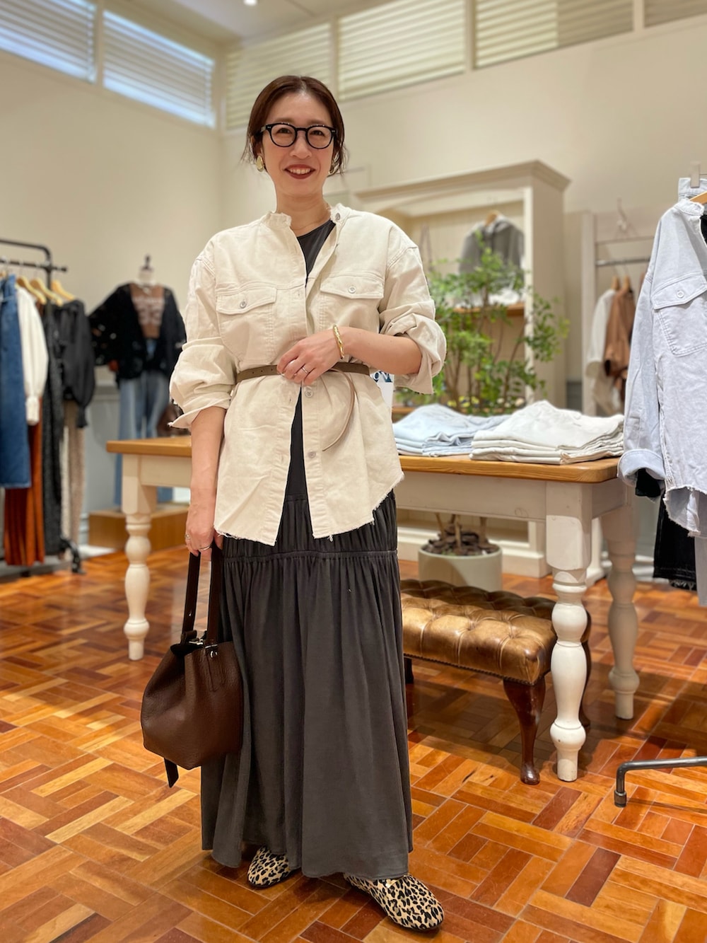 ホワイト系のシャツ/ブラウス、グレー系のワンピース、ブラウン系のショルダーバッグを着用したレディースの秋コーディネートの2枚目の写真