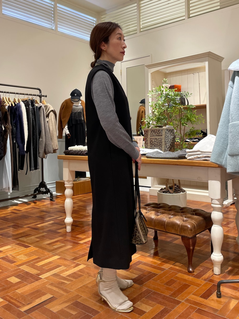 ブラック系のワンピース、グレー系のニット/セーター、ベージュ系のショルダーバッグを着用したレディースの冬コーディネートの7枚目の写真