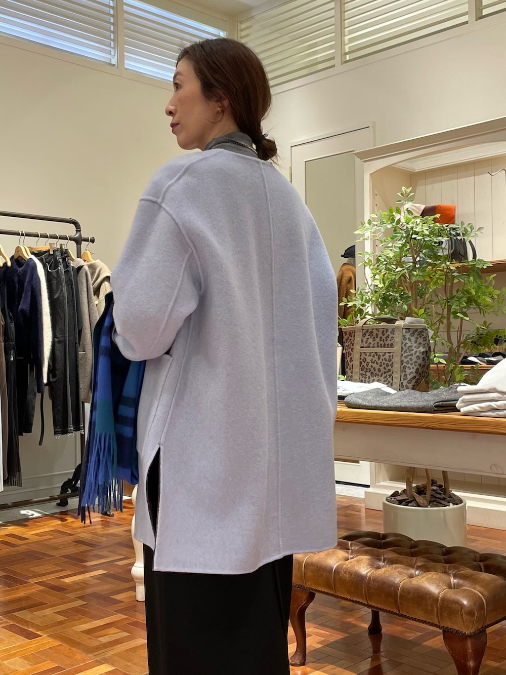 ブラウン系のノーカラーコート、ブラック系のワンピース、グレー系のニット/セーターを着用したレディースの冬コーディネートの10枚目の写真